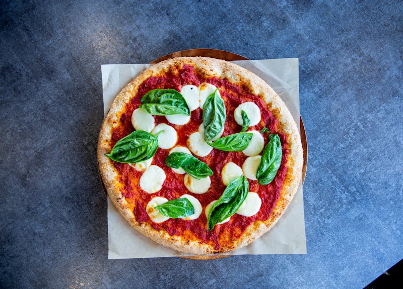 Signature Margherita Pizza with fresh basil and mozzarella